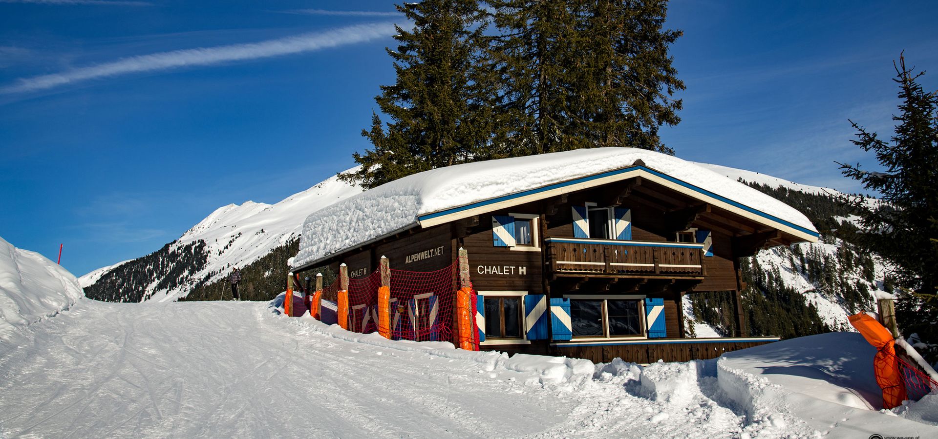 Tief verschneites Chalet H an der Skipiste unter blauem Himmel in Königsleiten
