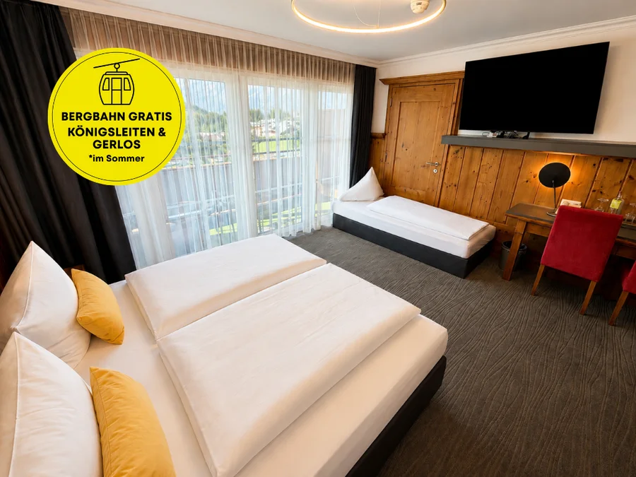 Premium-Zimmer mit Doppelbett, Einzelbett, Holzvertäfelung, Flat-TV, rotem Stuhl und großer Fensterfront